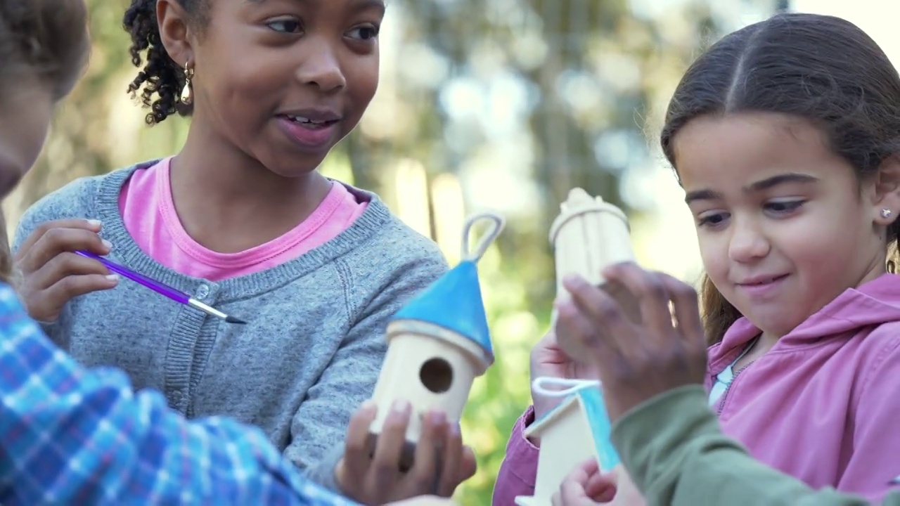 多种族儿童在社区花园画鸟屋视频素材