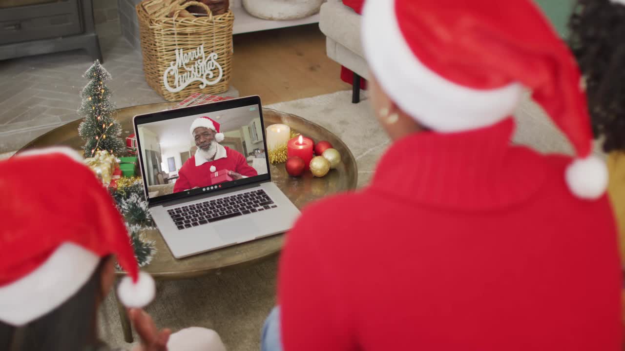 多样化的家庭与圣诞老人的帽子使用笔记本电脑圣诞视频电话屏幕上的快乐圣诞老人视频下载