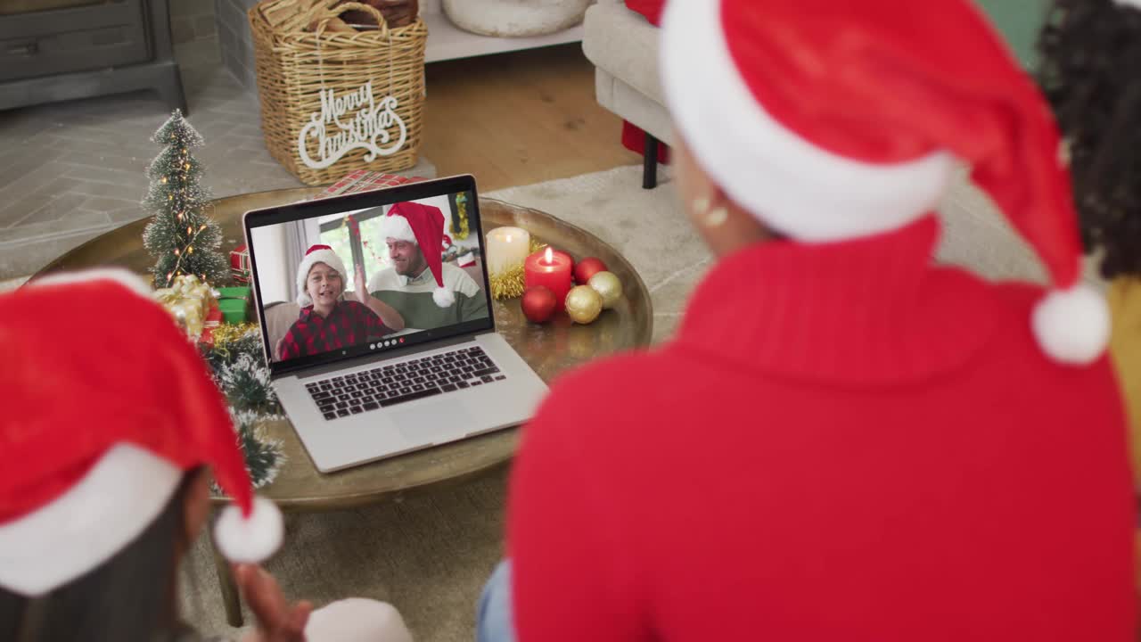 各种各样的家庭与圣诞老人的帽子使用笔记本电脑圣诞视频电话与幸福的家庭屏幕视频下载