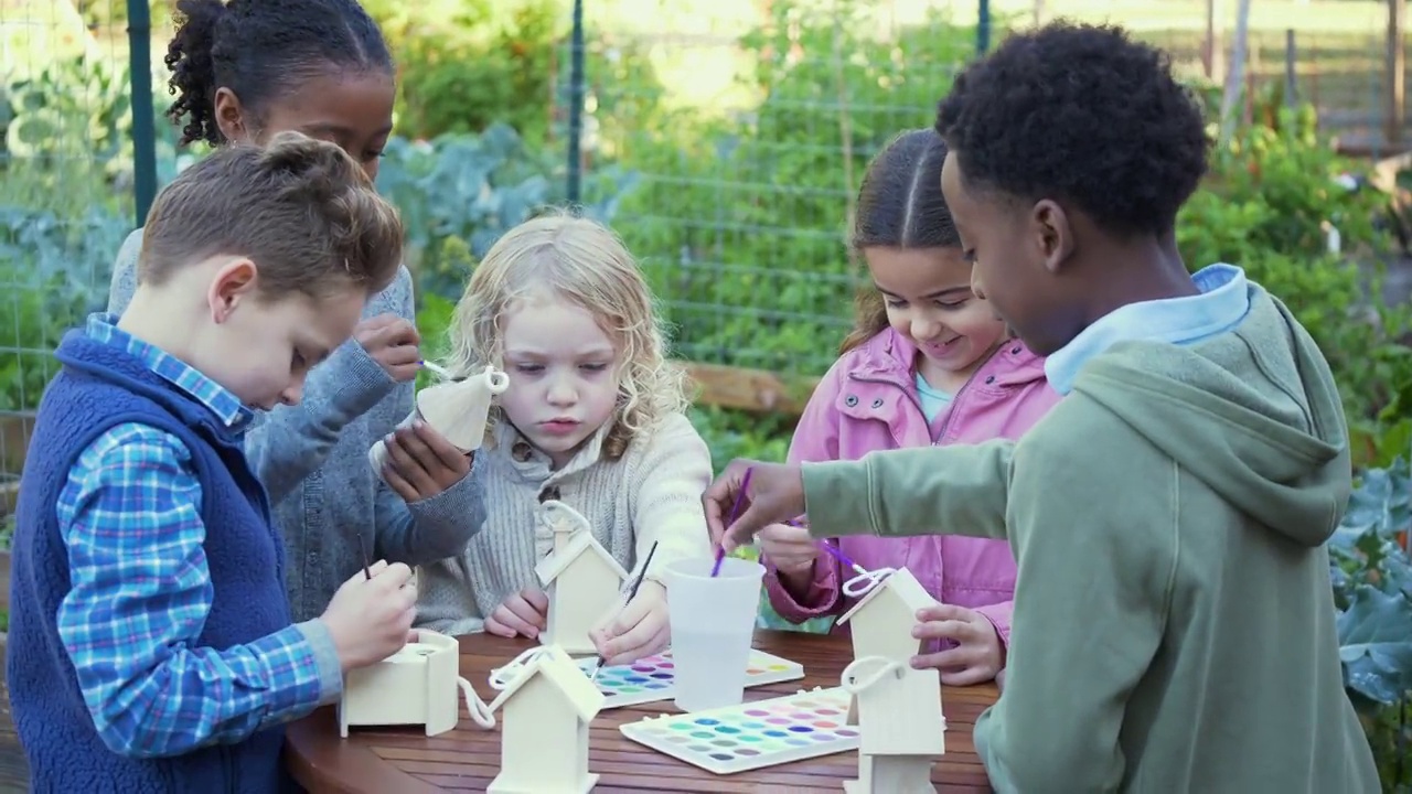 多种族儿童在社区花园画鸟屋视频下载