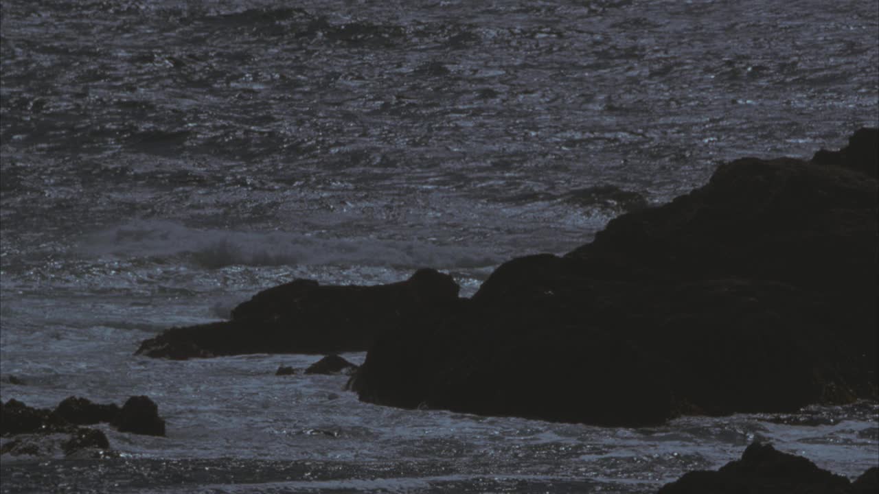 近角度海浪冲击岩石沿崎岖的海岸线。海洋。60 FPS。视频素材
