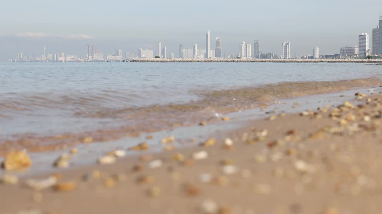 4K视频慢镜头近距离步行在海滩上远离大城市的背景。视频素材