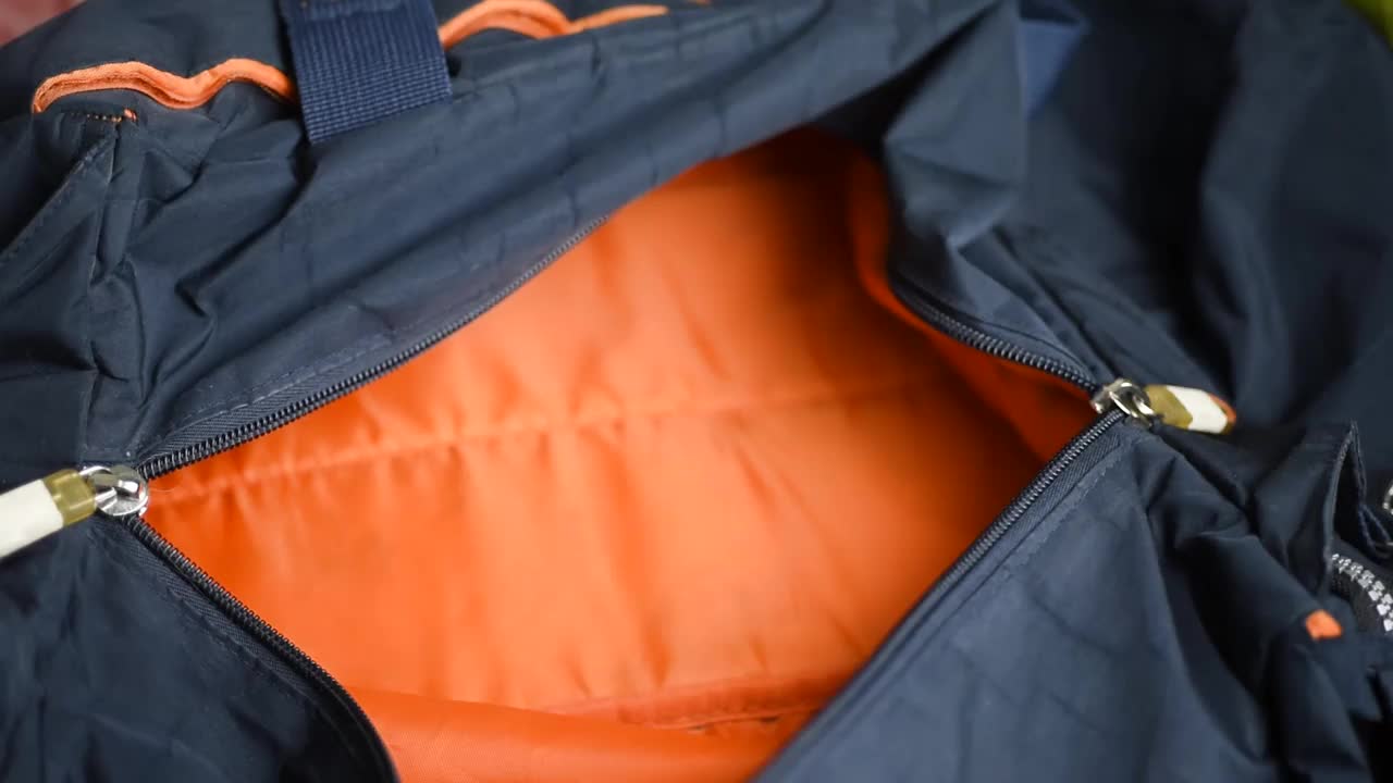 一个男人在运动包里收集衣服，特写镜头。视频下载