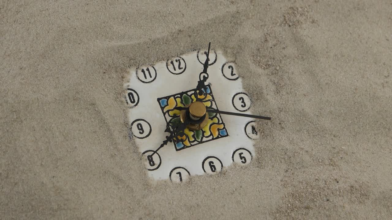 把时钟放在沙子上作为一个象征，那就是把时间放进沙子里，时间流逝视频素材