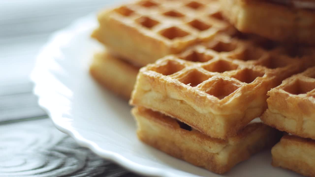 蜂蜜浇在新鲜的华夫饼上。比利时华夫饼早餐视频下载