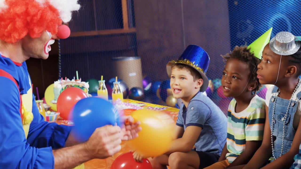 在生日派对上，五彩纸屑飘落在不同的孩子和小丑身上视频素材