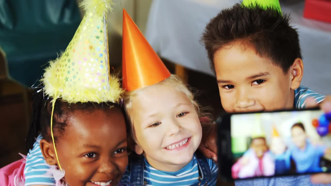 在生日派对上，五彩纸屑飘落在戴着派对帽子的孩子们身上视频素材