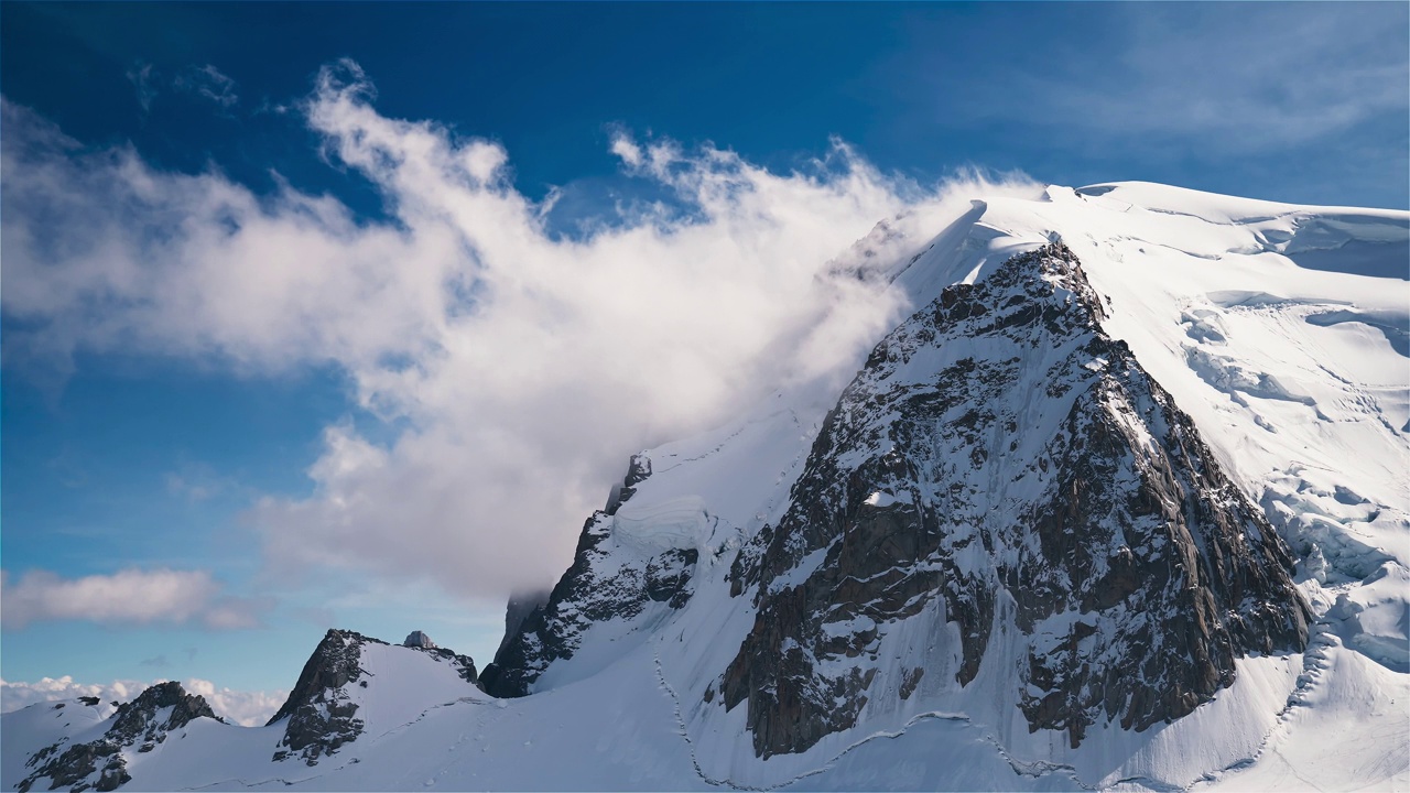 从空中俯瞰雄伟的阿尔卑斯山。陡峭的山峰上覆盖着冰山和积雪视频下载