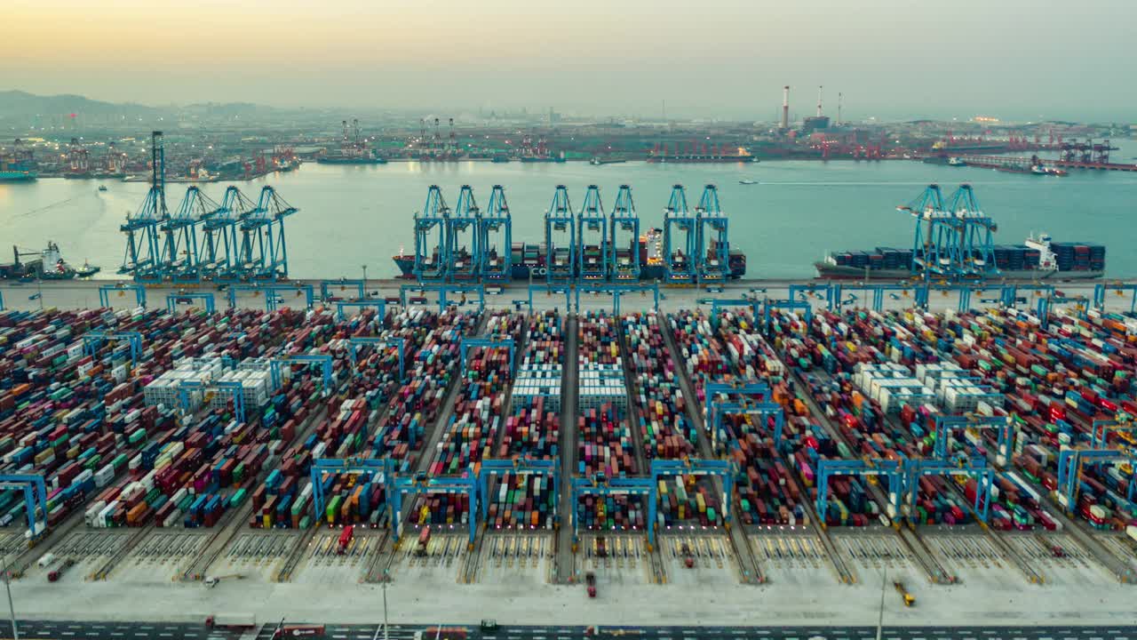 快速运动时间推移。中国山东省青岛市码头商港、商业物流和运输业集装箱货轮无人机航拍视频下载