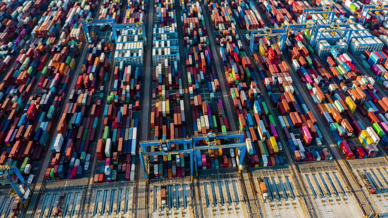 快速运动时间推移。中国山东省青岛市码头商港、商业物流和运输业集装箱货轮无人机航拍视频下载