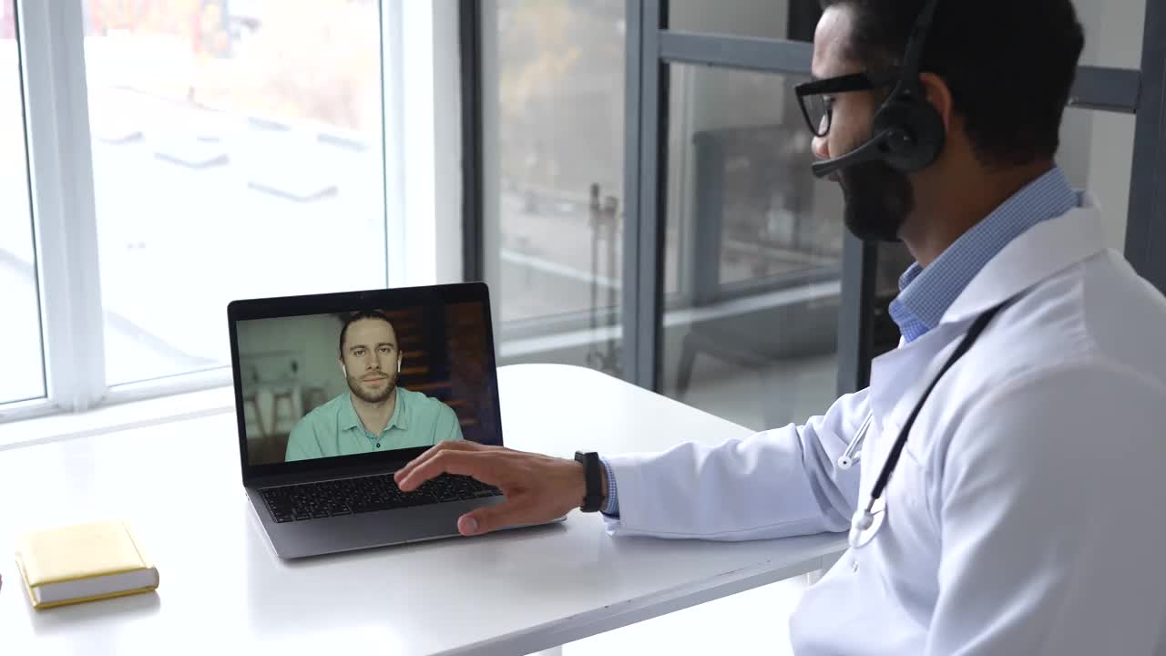 印度男医生使用笔记本电脑在线与病人会面，听取投诉视频素材