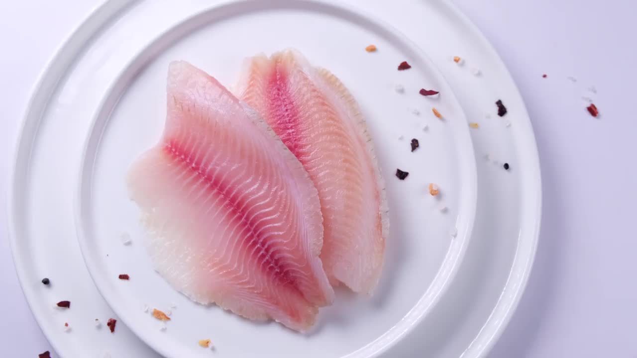 鱼柳或其他海鱼的特写，与香料和盐放在盘子里视频下载