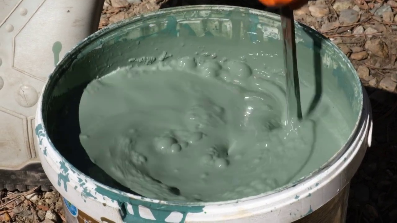 在桶中搅拌混合水基漆。慢动作视频素材