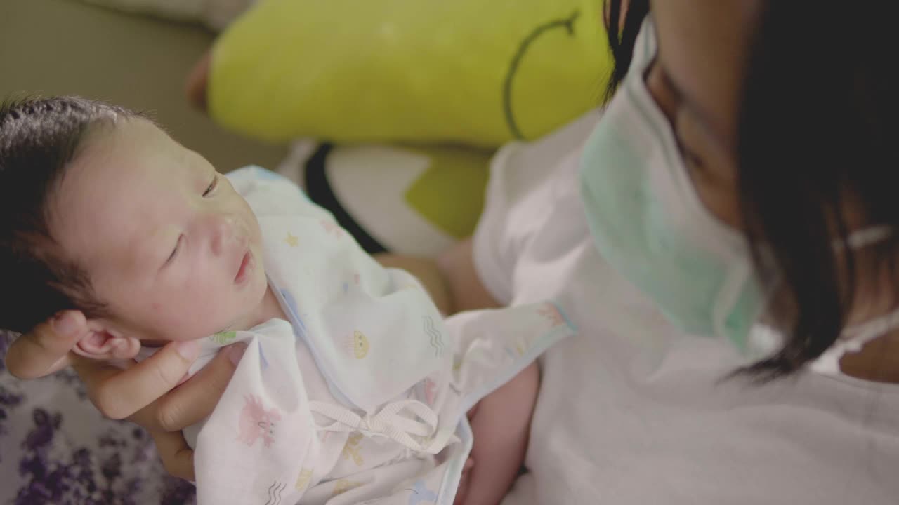 亚洲母亲抱着熟睡的新生儿在家里视频素材