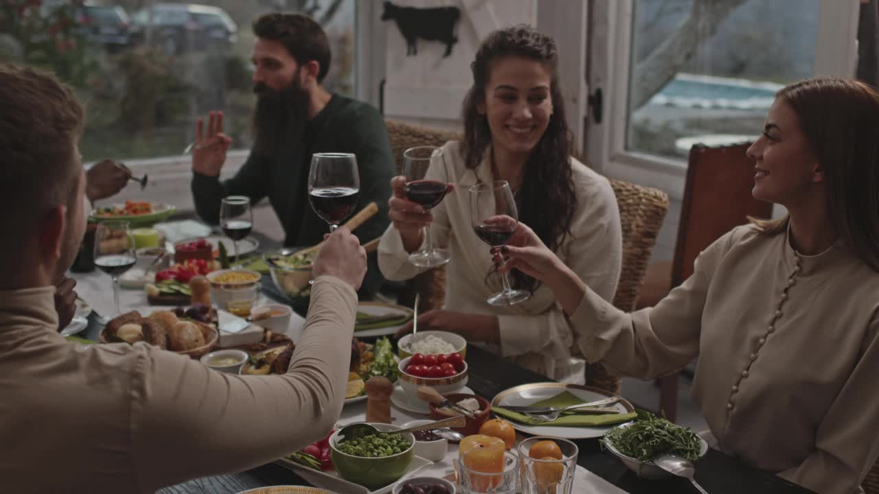 朋友们在餐桌上喝着红酒，享受着晚餐视频下载