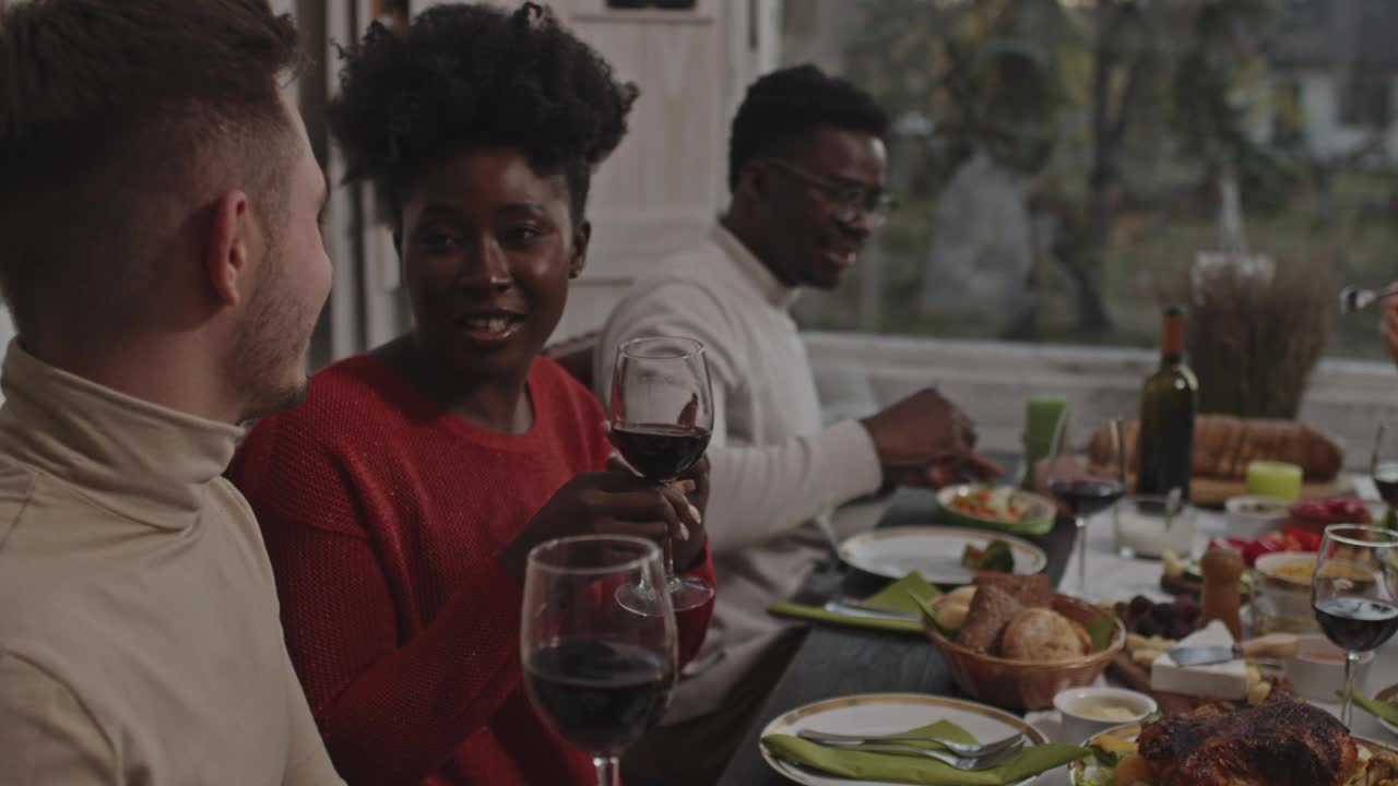 朋友们在圣诞晚宴上谈论着他们正在享用的红酒视频下载