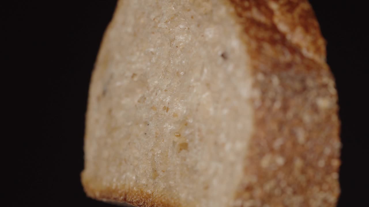 亚麻籽面包，切片。在黑色背景上旋转视频素材
