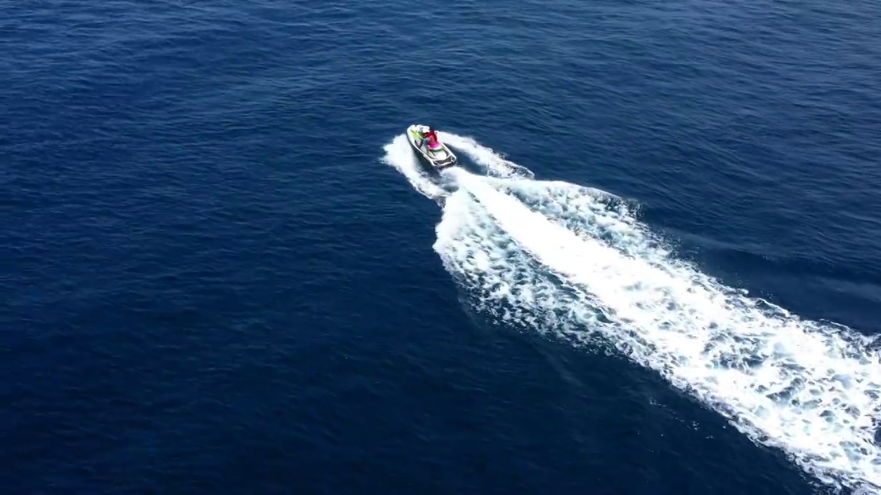 航拍的男人和女人在度假期间骑在蓝色的海摩托艇-马尔代夫，马尔代夫视频下载