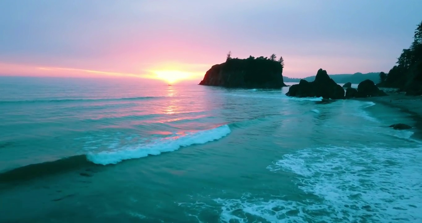 航拍美丽的岩石在红宝石海滩，无人机飞行在海洋在日落视频下载