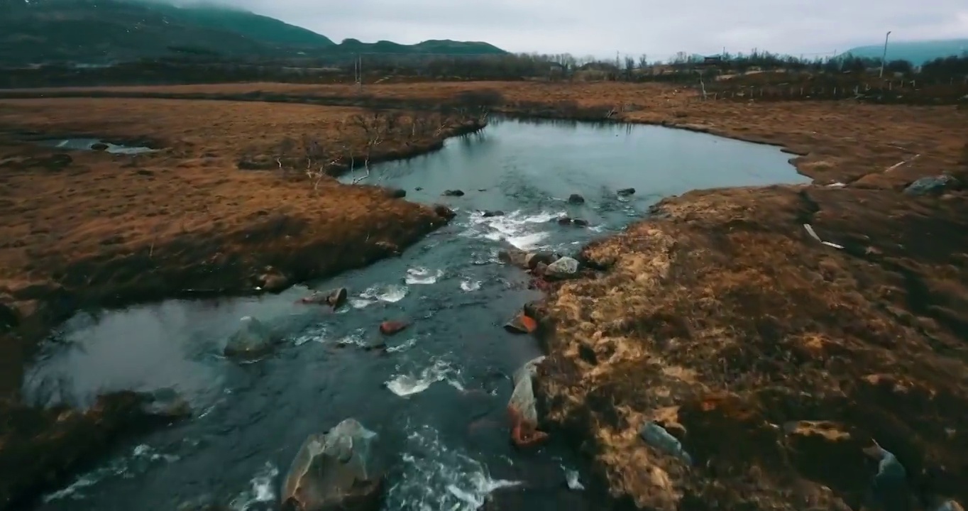 在冬天，无人机在河上飞行，挪威特罗姆瑟市，岩石的空中向前美丽的视图视频素材