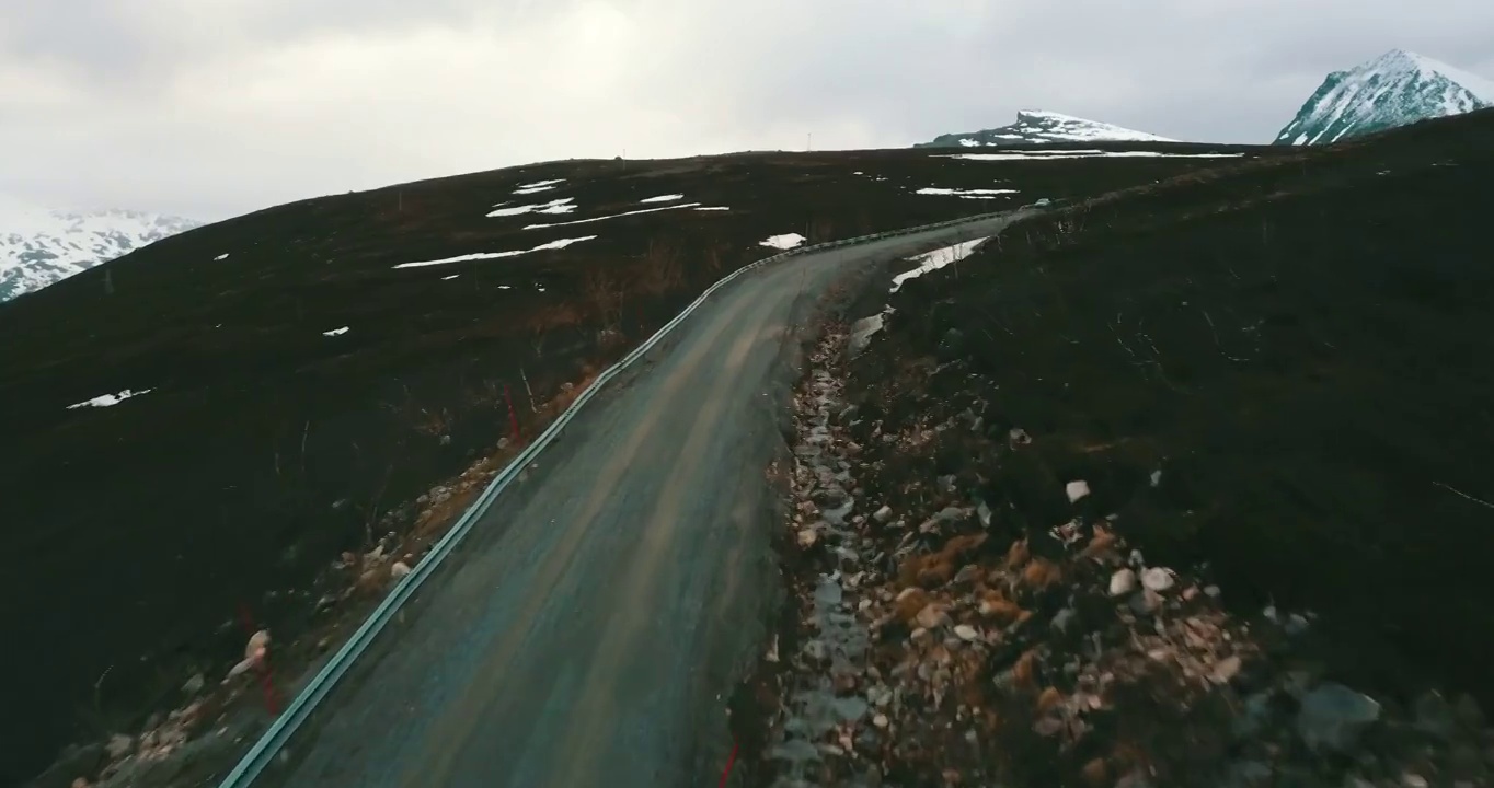 空中前进美丽的镜头，空的山路，无人机飞行在冬季-特罗姆瑟市，挪威视频下载