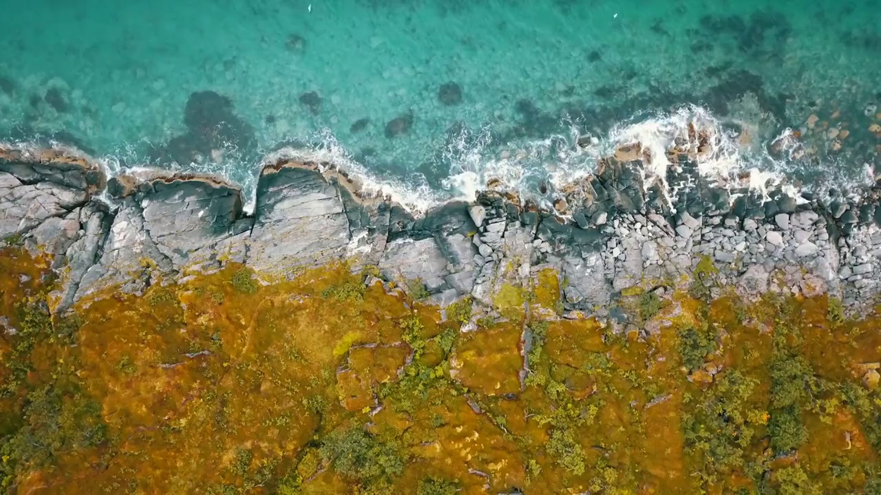 空中顶部封锁风景镜头浪花飞溅在景观上，鸟飞过蓝绿色的海-特罗姆瑟市，挪威视频下载
