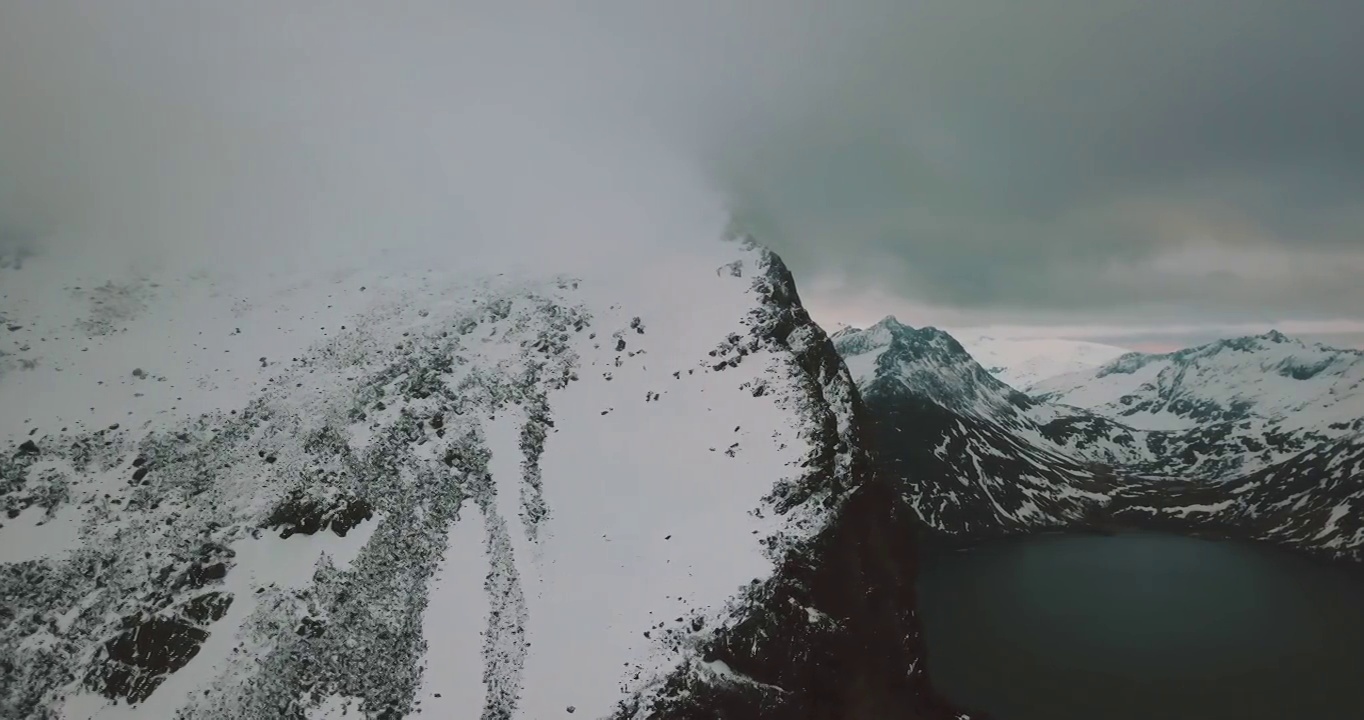 空中风景拍摄的海在雪山对白色多云的天空-特罗姆瑟市，挪威视频下载