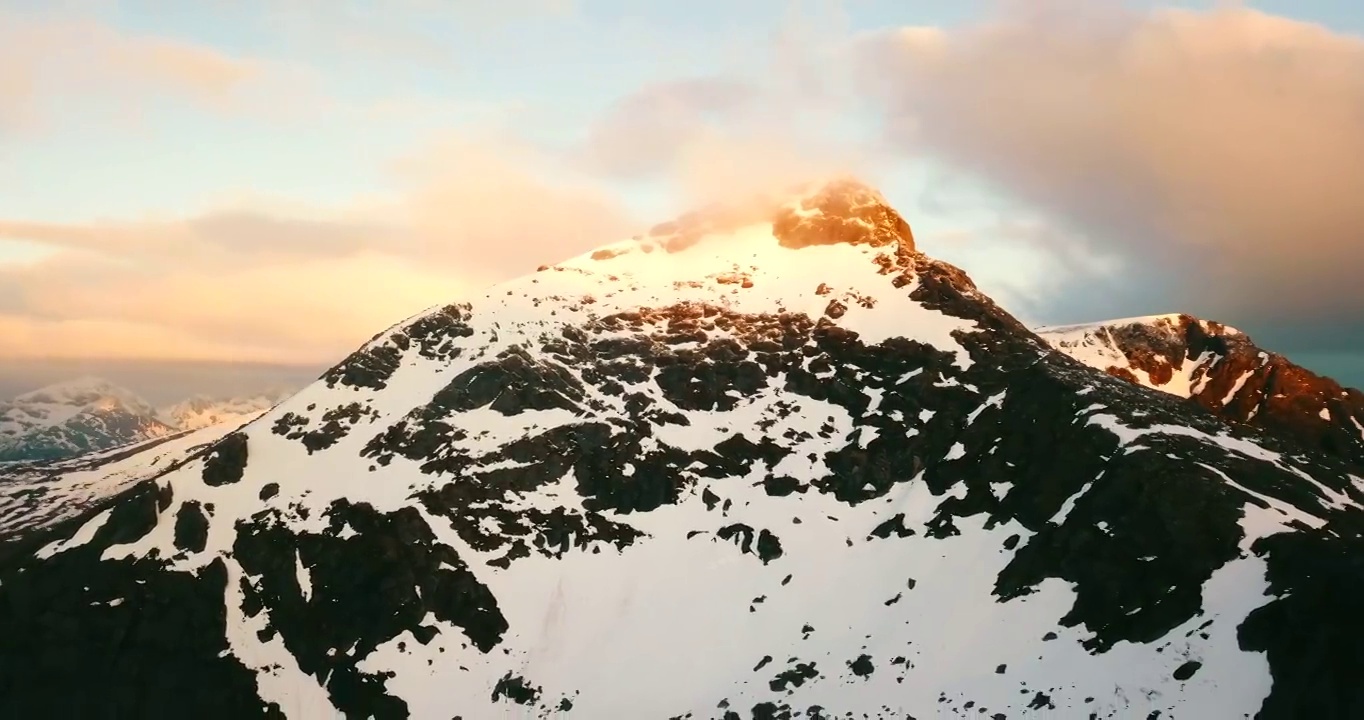 挪威特罗姆瑟市，海上积雪覆盖的岩层上的阳光的空中向后拍摄视频下载