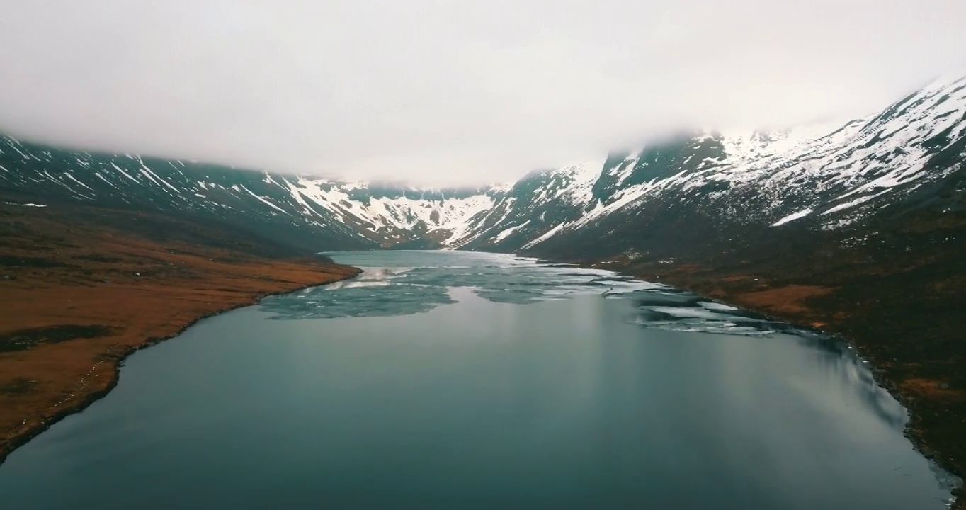 空中冰冻的湖在岩层中，无人机在景观上向后飞行-挪威特罗姆瑟市视频下载