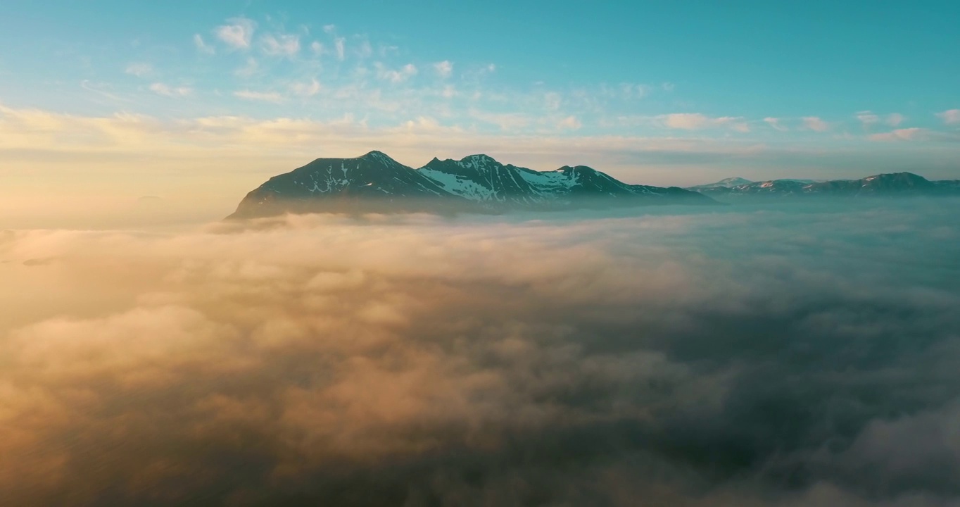 空中风景拍摄的雪的岩石在日落，无人机飞行在白色的云在冬季-特罗姆瑟市，挪威视频下载