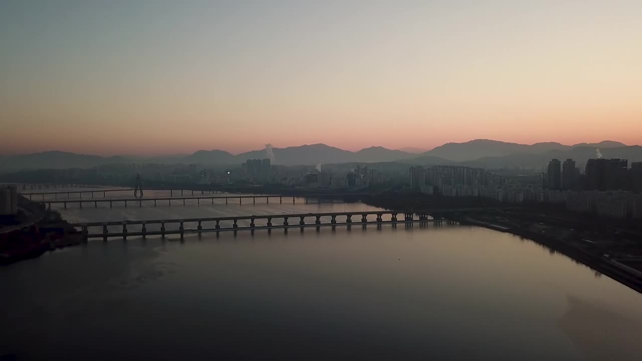 汉江、汉江公园、蚕室大桥、奥林匹克大桥、乐天世界塔、首尔松坡区蚕室区附近的公寓等地的日出美景视频下载