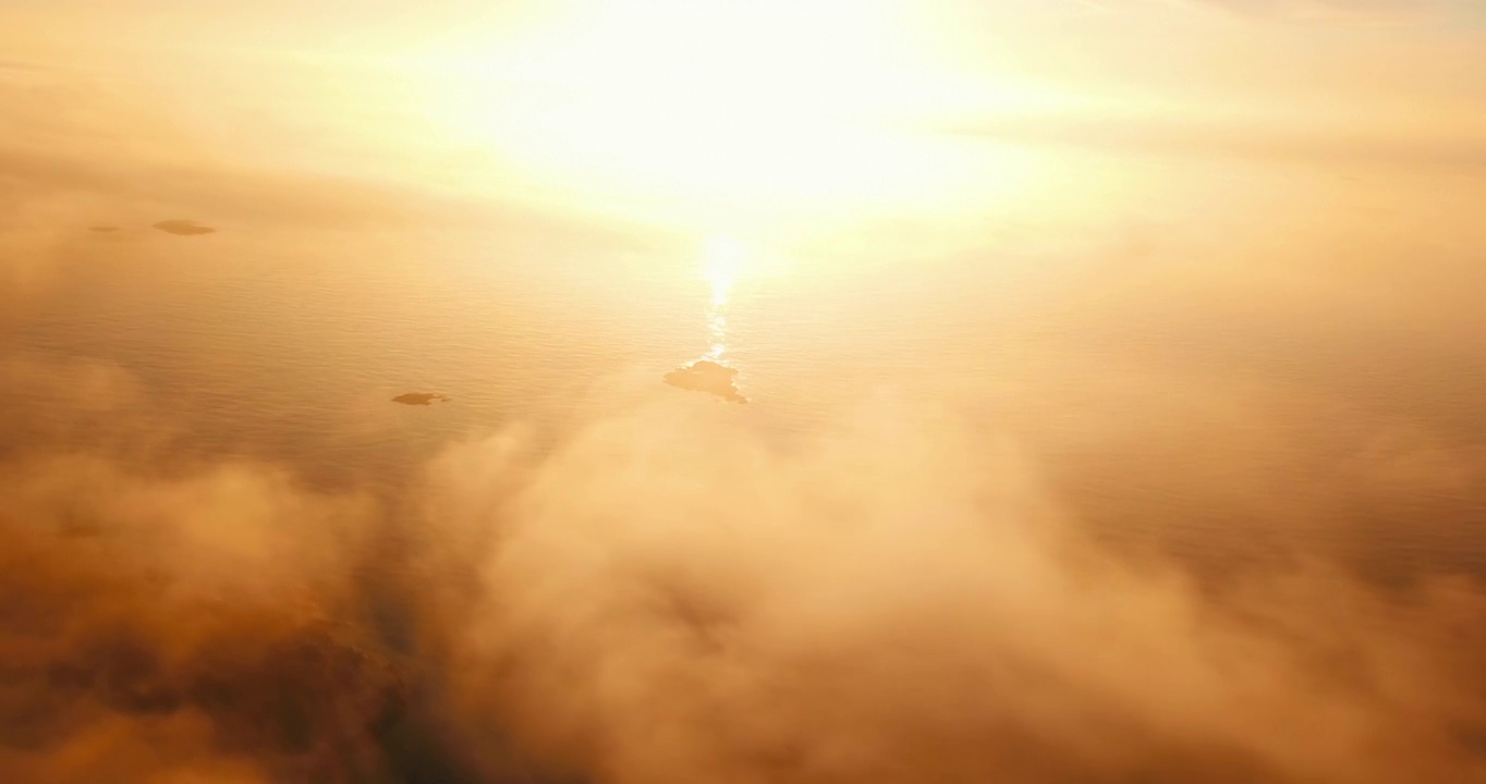 在日落期间，无人机在云中飞行，挪威特罗姆瑟市，海水的空中平移下降风景镜头视频下载