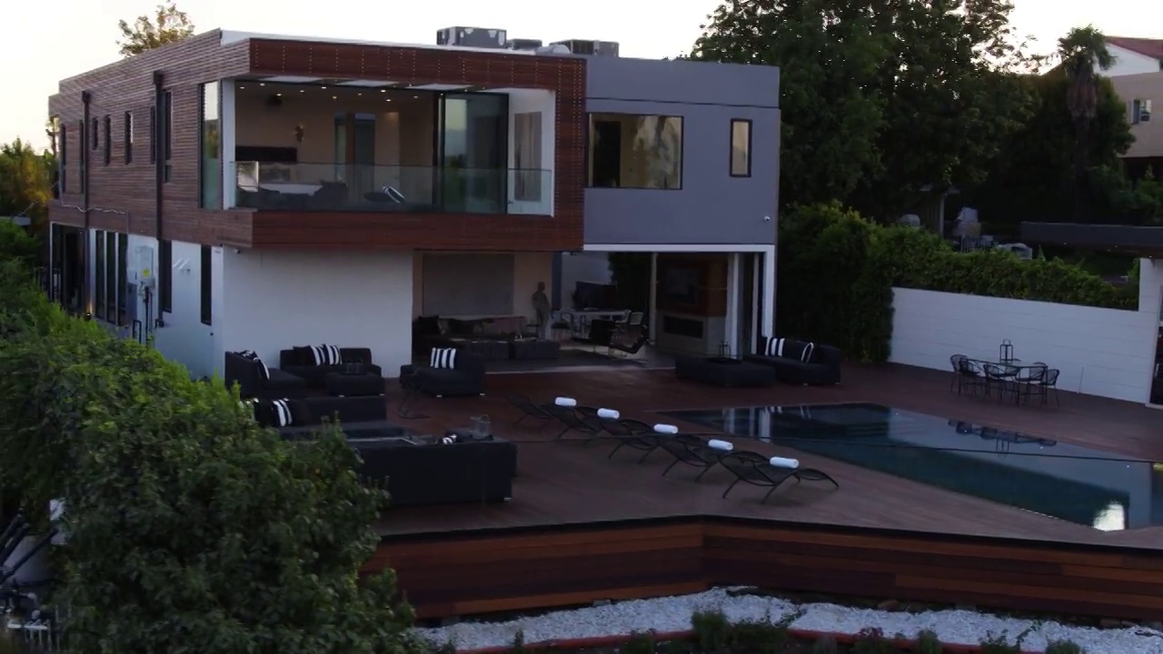 空中拍摄的男子站在城市夕阳下的现代住宅-洛杉矶，加利福尼亚视频下载