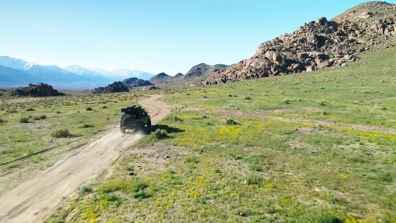 空中越野车在公路上向山区移动，无人机飞行在绿色景观- Sierra，加利福尼亚州视频素材