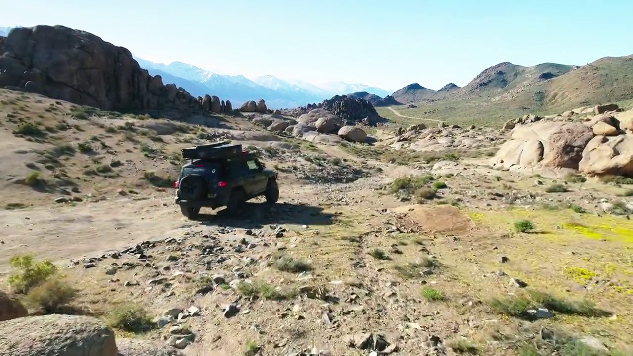 空中前进吉普车在阳光明媚的一天向山脉移动-塞拉，加利福尼亚视频素材