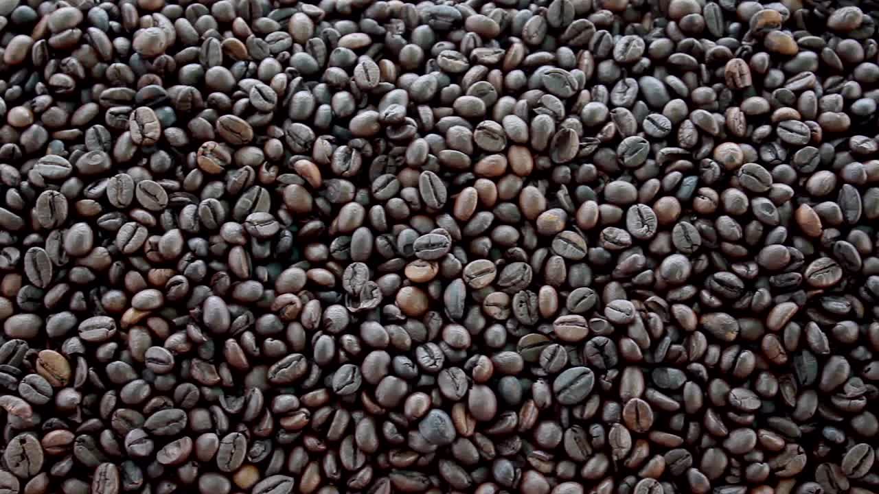 咖啡豆顶部向下的特写镜头。阿拉比卡烘焙种子食品。黑咖啡豆。视频素材