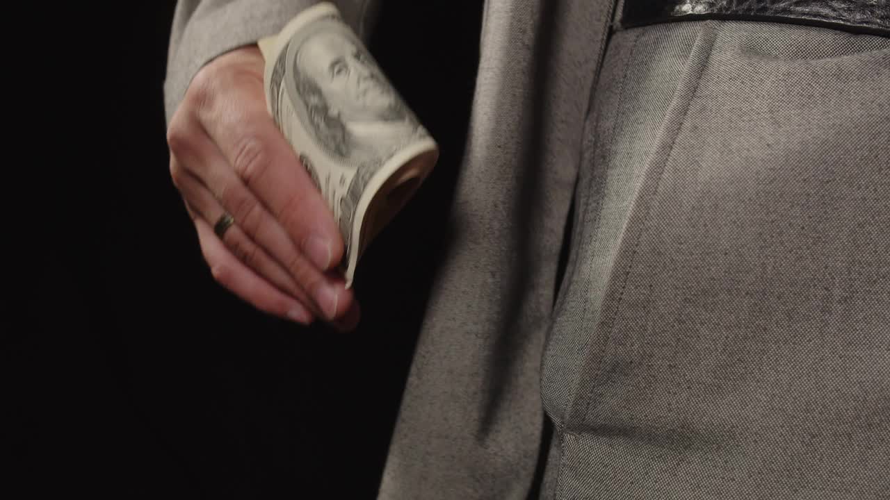 西装男把美元放在口袋里。腐败视频下载