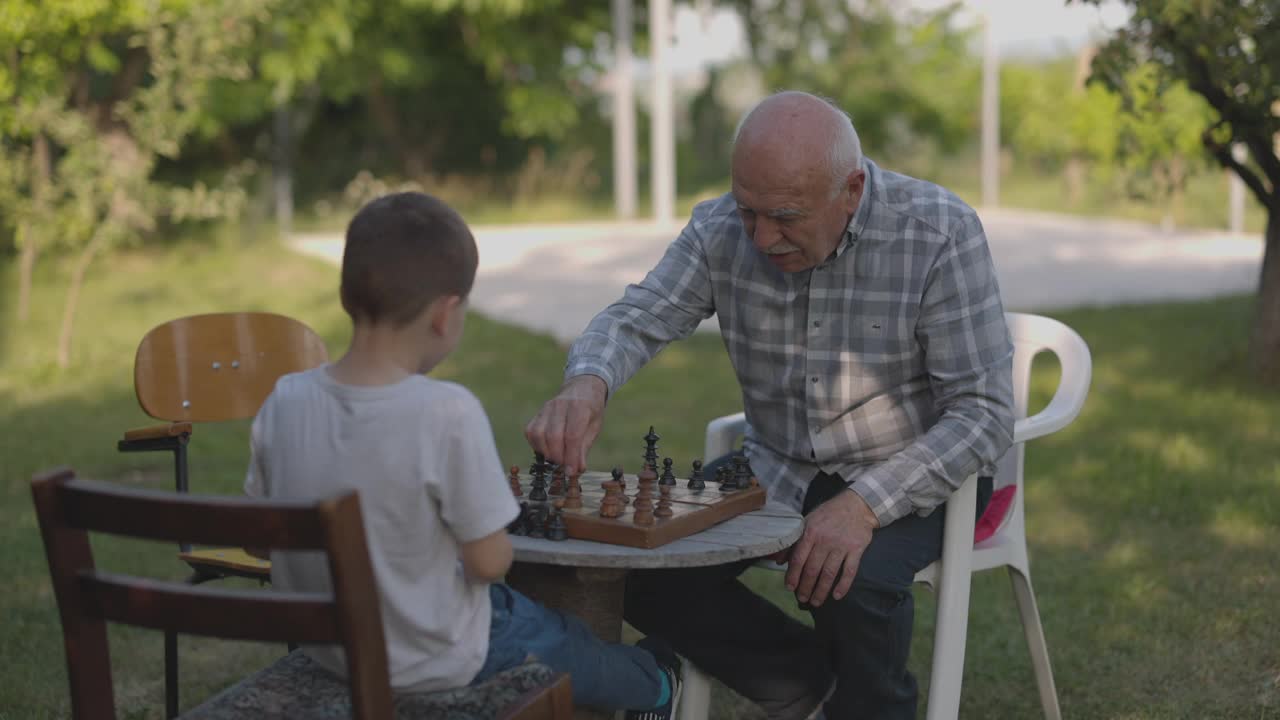 爷爷和孙子在院子里下棋视频素材