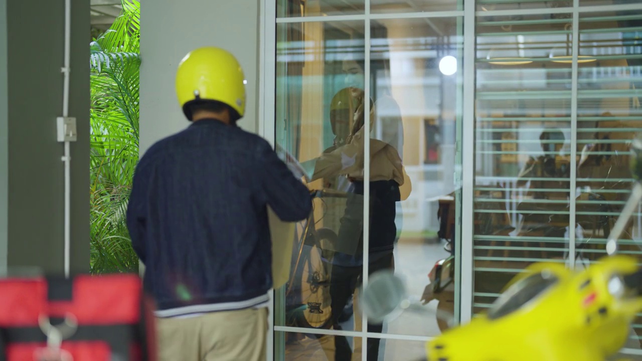 亚洲女送餐员戴着头盔按门铃送食品视频素材