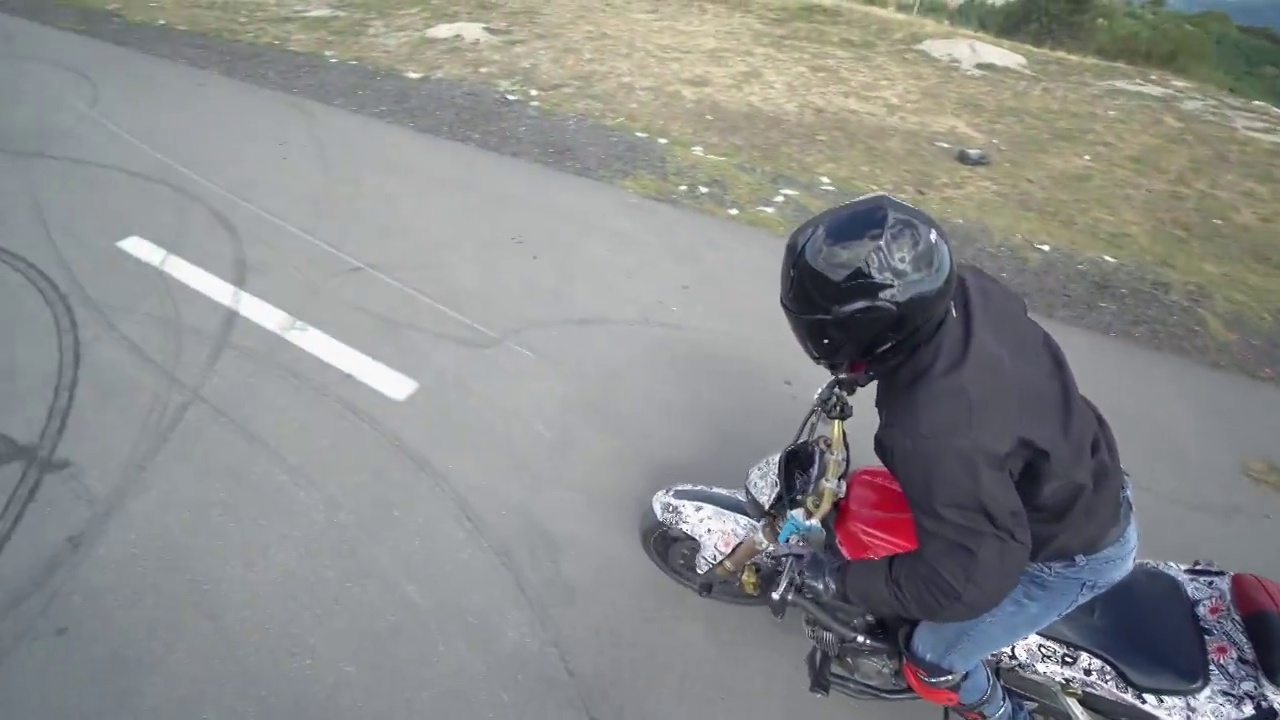一名戴着头盔的摩托车手在摩托车表演上表演危险的特技和特技视频下载