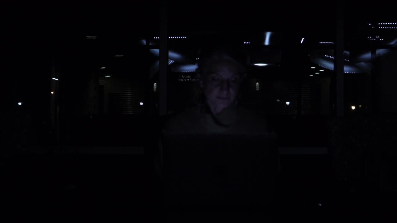 成熟的成年女性在工作空间与电源和灯熄灭完成任务的笔记本电脑业务视频系列视频下载