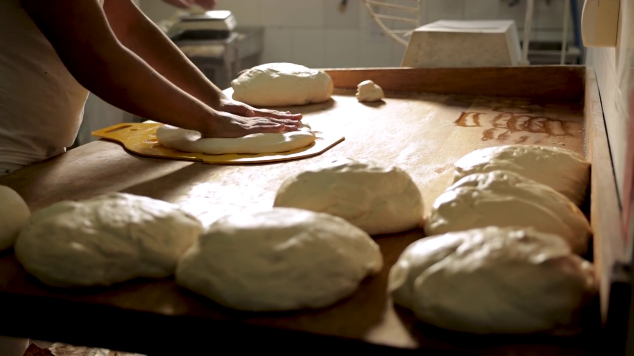 在面包房的厨房里，面包师用面团制作小面包视频下载