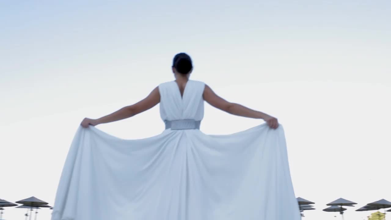 美丽的年轻时装模特走在白色飘动设计师的夏季连衣裙视频下载