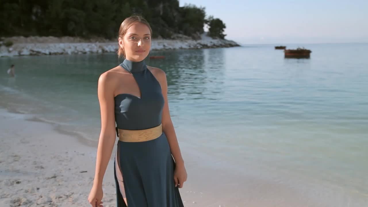 美丽年轻的时装模特走在海边，穿着设计师们飘逸的夏装视频下载