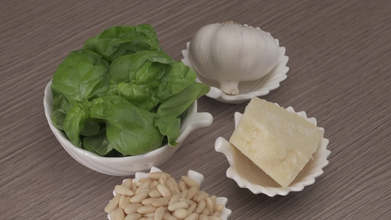 意大利传统香蒜沙司配料旋转。新鲜的生罗勒，松子，大蒜，帕尔马干酪家庭自制地中海饮食健康食品视频素材