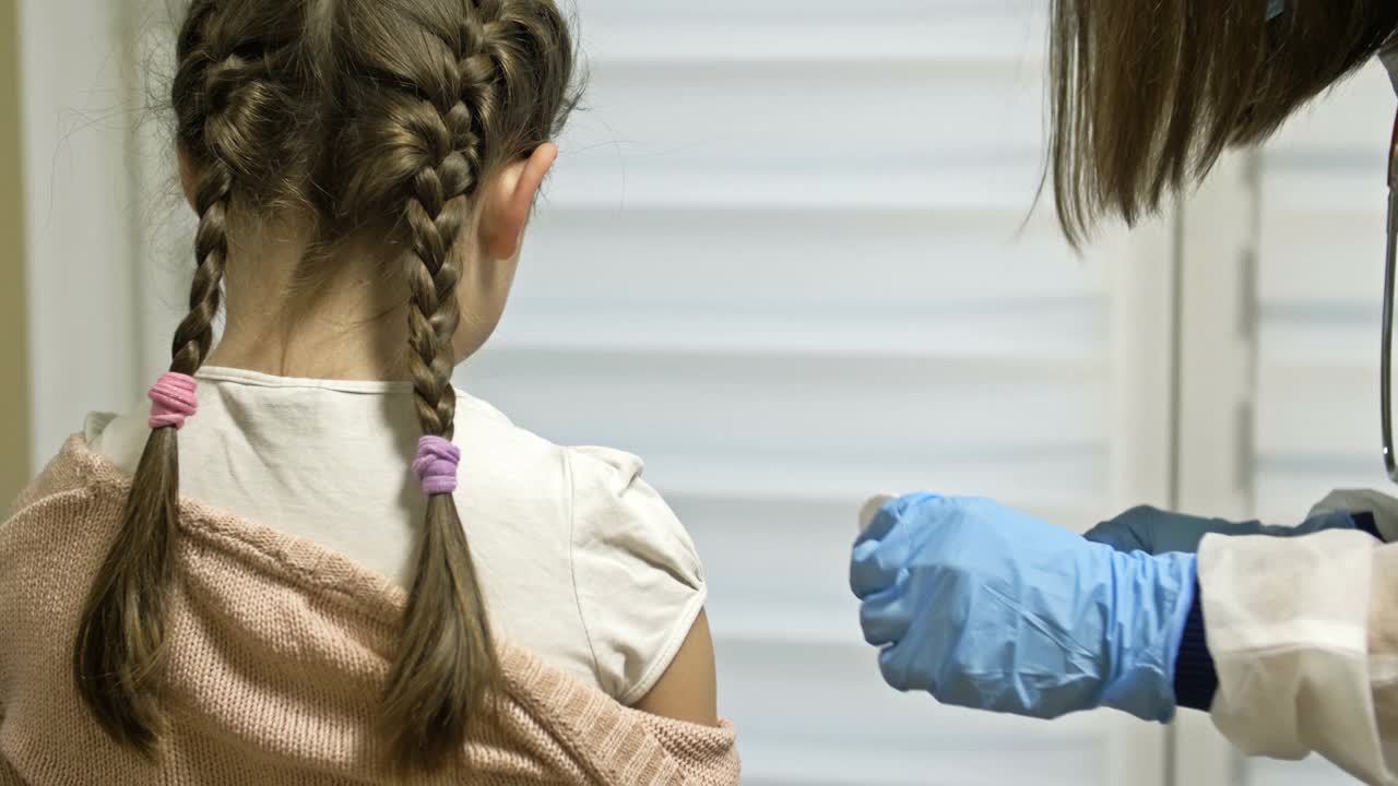 正在给学龄女孩接种疫苗。强制性的疫苗接种。这孩子在诊所里肩部注射了疫苗视频素材