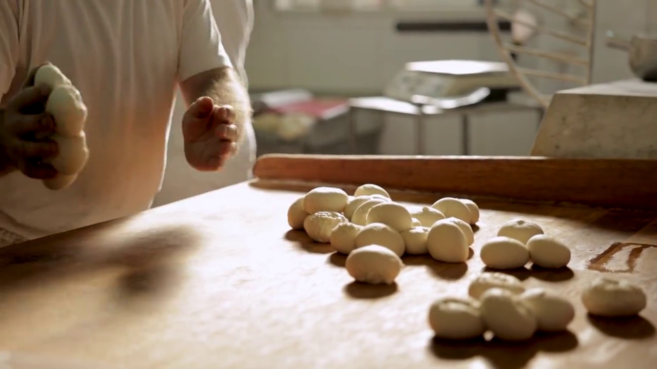面包房厨房的面包师在做小圆面包视频下载