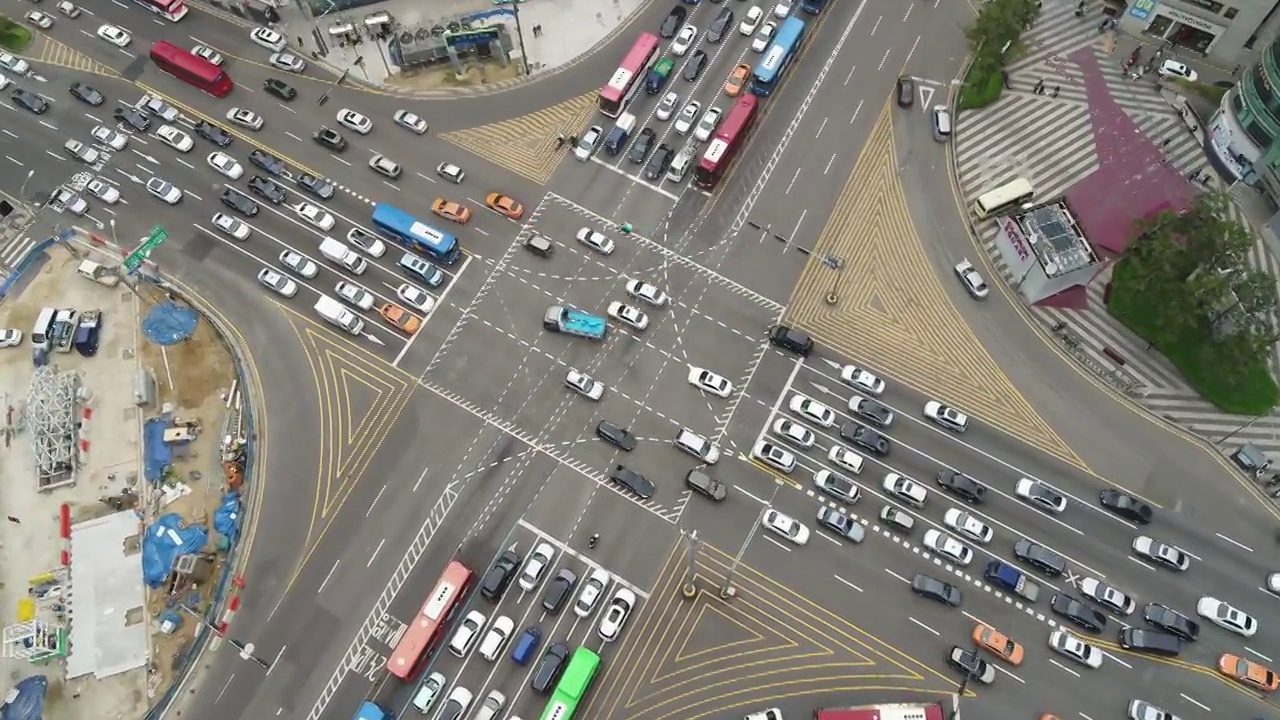 韩国首尔江南区江南大路附近的摩天大楼和江南站交叉路口行驶的汽车视频下载