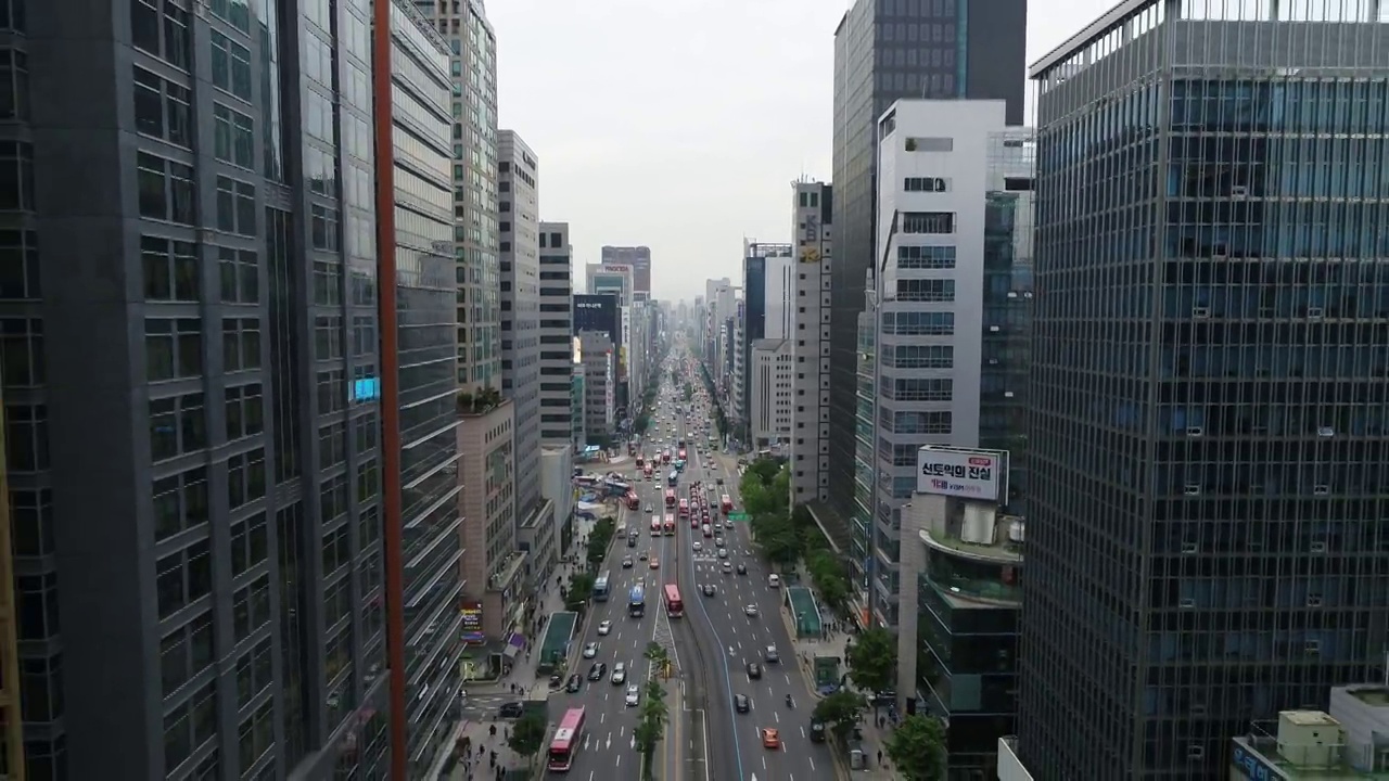 韩国首尔江南区江南大路附近的摩天大楼和江南站交叉路口行驶的汽车视频下载