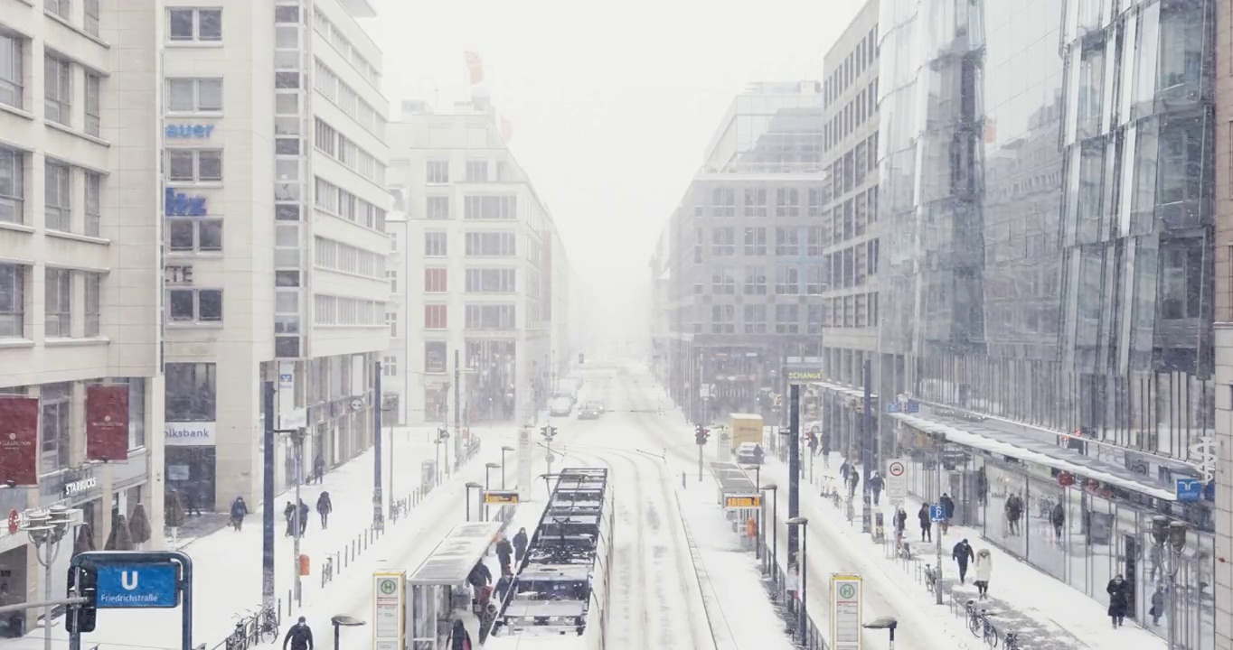 柏林弗里德里希大街城市冬季天际线街道场景与交通和暴风雪在慢动作视频下载
